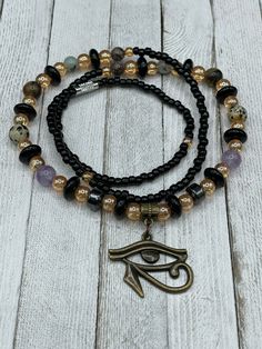 "🌟 Welcome to our shop! 🔥 ✨ Our handmade \"I am Protected\" Waist Beads with Eye of Horus Charm are the perfect blend of tradition and spirituality. ✨ 💎 Made with the highest quality materials and crafted with care, our waist beads are stretchy and come with a clasp for easy wearing and adjusting. They feature a beautiful Eye of Horus charm and multiple crystals including Amethyst, Hematite, Jasper, and Tiger Eye. Each of these crystals holds powerful energy that can enhance your spiritual jo Symbolic Gemstone Beads Jewelry For Meditation, Adjustable Amulet Beaded Bracelets With Round Beads, Beaded Amulet Jewelry For Meditation, Adjustable Amethyst Beads For Jewelry Making, Spiritual Polished Round Bead Jewelry, Adjustable Jewelry With Polished Oval Beads, Adjustable Amethyst Jewelry With Polished Beads, Black Amethyst Beads Jewelry 8mm, Spiritual Polished Round Beads Jewelry