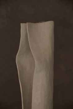 a tall white vase sitting on top of a table