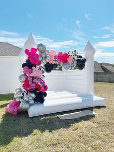 an inflatable arch is decorated with balloons and other decorations for a birthday party