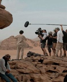 a group of people are filming in the desert