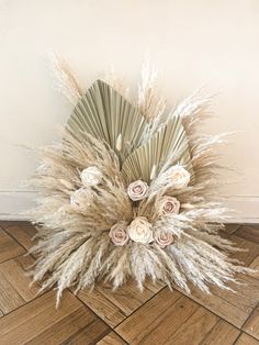 an arrangement of dried flowers and grass on the floor