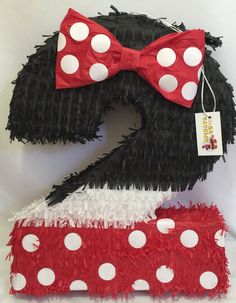 the number two is made out of black and white feathers with red polka dots on it