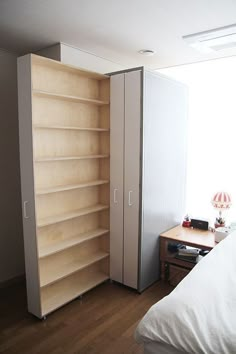 a bedroom with a bed, desk and bookcase