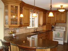 a kitchen with wooden cabinets and granite counter tops, an island in the middle is surrounded by bar stools