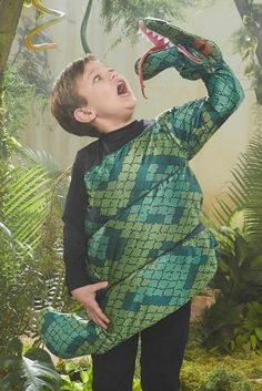 a young boy is holding an animal in his hands and looking up into the air