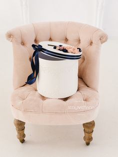 a pink chair with a blue ribbon around it and a white bucket on the back