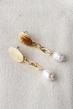 KRISA Earrings: Beautiful and Elegant 18k Gold plated and freshwater pearls drop earrings, Perfect for wedding day or any ocassion. These simple yet stunning earrings are the perfect gift for a mom, sister, daughter, niece, aunt, granddaughter, or friend! FEATURES: * 18K gold plated stud earring base *7mm natural freshwater pearls  *18K Gold-plated chain CARE INSTRUCTIONS: *Remove before exercising taking a shower/bath and sleeping. *Avoid contact with moisture such as water, perfume, and other Oval Pearl Earrings For Gifts, Oval Pearl Drop Earrings Gift, Oval Pearl Earrings With Pearl Charm Gift, Gold Pearl Drop Earrings As Gift, Gold Pearl Drop Earrings For Gift, Gift Oval Pearl Drop Earrings, Gold Plated Teardrop Pearl Earrings For Gift, Gold Minimalist Pearl Earrings For Wedding, Gold Earrings With Pearl Chain For Anniversary