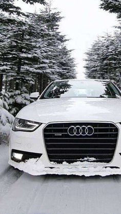 a white car driving down a snow covered road