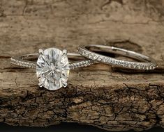 two engagement rings sitting on top of a piece of wood