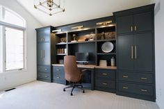 a home office with built - in cabinets and a desk, along with a chair