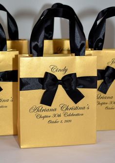 three gold bags with black bows on them