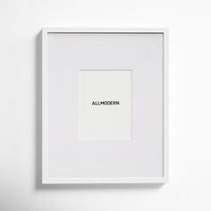 a white frame with the word all modern printed in black on it, against a white wall