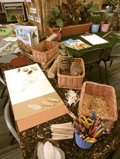 the table is covered with books and baskets full of crafting supplies for kids to make