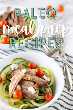 a white bowl filled with meat and veggies on top of a striped table cloth