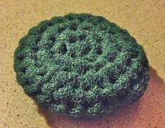 a green crocheted object sitting on top of a table