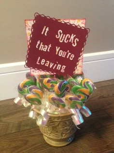 there is a sign that says it sucks that you're leaving on top of some lollipops