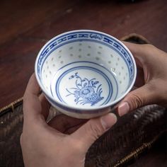 a person holding a blue and white bowl