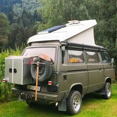 an off road camper parked in the grass with its roof tent on it's back