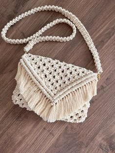 a white crocheted purse on a wooden floor