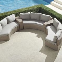 an outdoor sectional sofa with cushions next to a swimming pool