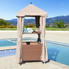 a gazebo next to a swimming pool with mountains in the background and a wicker basket under it