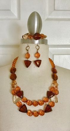 "I insert a mixture of glass, transparent acrylic beads, round, triangle, and oval-shaped beads with shades of brown, finishing it off with antique copper findings clasps and ear wires, all on the beading wire. Necklace 22\" long Bracelet 8 1/2\" long Earrings 2 1/2\" long" Brown Necklace Jewelry, Long Bracelet, Cherry Necklace, Glass Transparent, Brown Necklace, Rainbow Necklace, Wire Necklace, Shades Of Brown, White Necklace