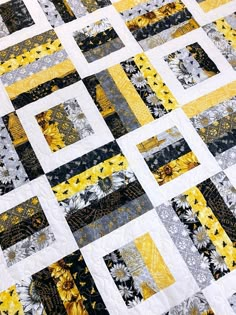 a yellow and black quilt with sunflowers on the bottom, along side it