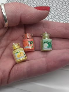 three miniature jars in the palm of someone's hand, each containing different flavors