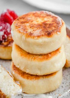 three pancakes stacked on top of each other with raspberries and powdered sugar