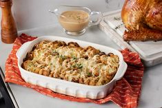 a casserole dish filled with chicken and vegetables next to a roasting pan