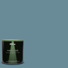 a can of behr marquee paint on a green background