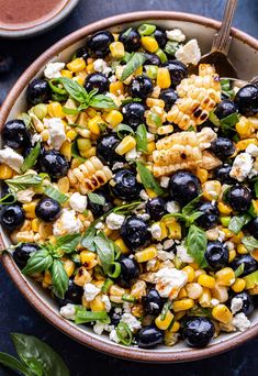 a bowl filled with corn and blueberries