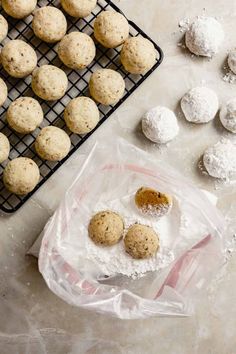 cookies and powdered sugar on a cooling rack, next to a tray of powdered sugar