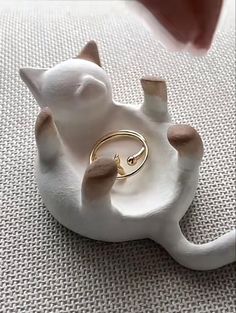 a close up of a cat figurine with a ring on it's back