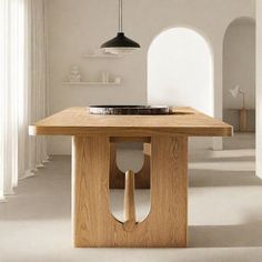 a wooden table in an empty room with white walls and flooring on the other side