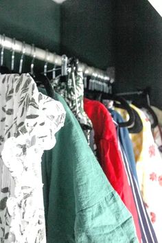 several shirts hanging on a rack in a closet