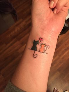 a cat and mouse tattoo on the wrist