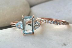 two engagement rings, one with an aqua blue topazte and the other with white diamonds