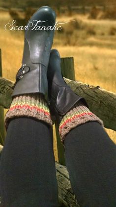 the legs of a person wearing black boots and socks with knitted leg warmers