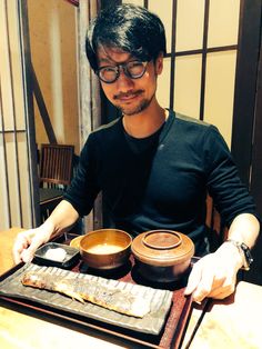 a man sitting at a table with some food in front of him on a tray