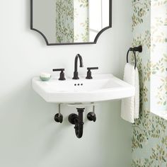 a white sink sitting under a bathroom mirror next to a wall mounted faucet