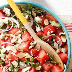 watermelon salad with feta cheese and almonds in a blue bowl on a table