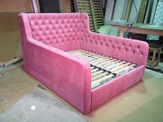 a pink couch that is in the middle of some kind of workbench,