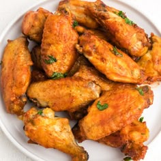 chicken wings on a white plate with parsley