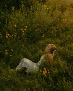 a woman laying in the grass with her eyes closed