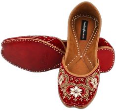 a pair of red shoes with embroidered flowers on the bottom and soles that are not in use