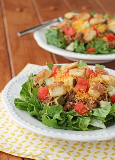 two plates filled with salad on top of a wooden table