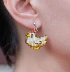 a close up of a person's ear wearing earrings made out of legos