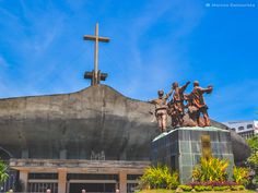 the statue is on display in front of an old building with a cross above it