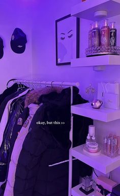 a closet with purple lighting and lots of clothes hanging on the shelves in front of it